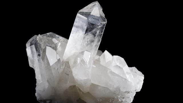 Crystalline silica mineral specimen on black background for silica safety training