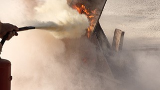 Fire extinguisher discharging white spray during fire extinguisher training