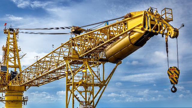 Yellow pedestal-mounted crane at construction site during pedestal crane operator training
