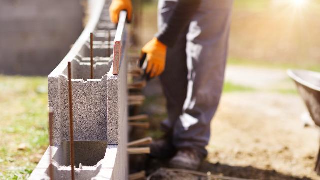 Workers laying concrete blocks at a construction site during concrete safety training