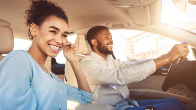 Driver and passenger wearing seatbelts in a car during defensive driving training