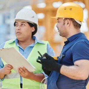 Construction supervisor with clipboard and worker reviewing jobsite safety for a California IIPP